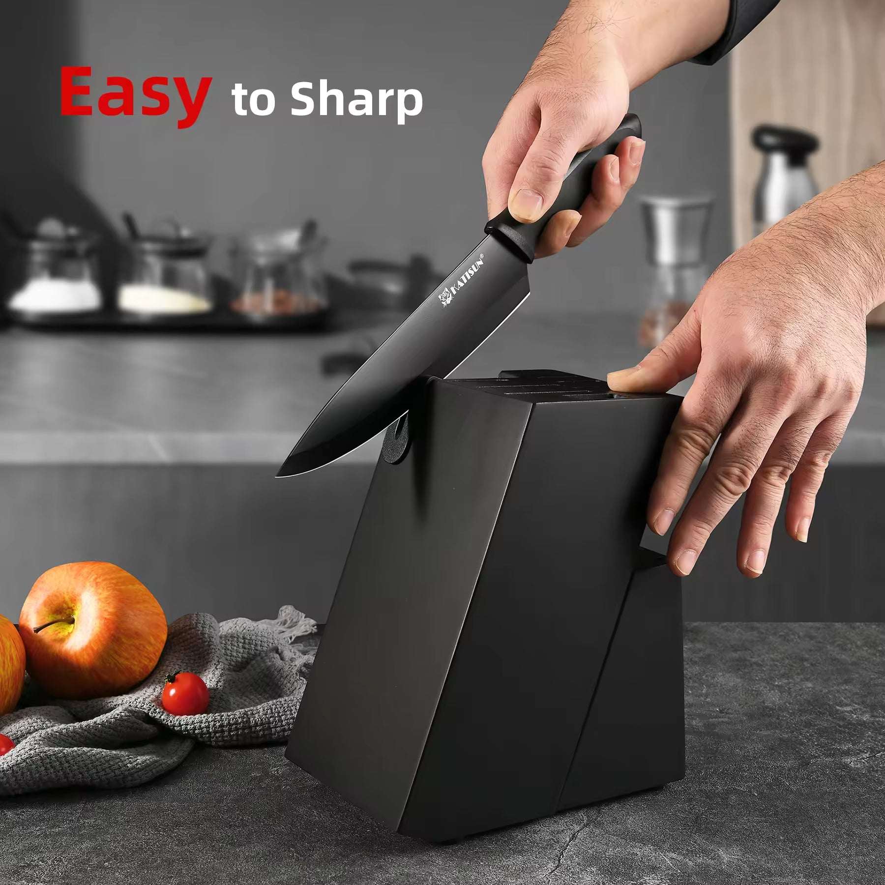 Black kitchen knife set being sharpened; hands hold a knife over the block