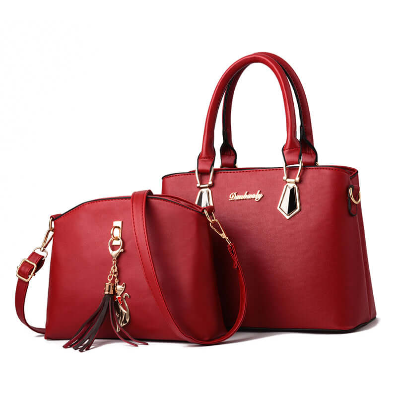 Red faux-leather crossbody handbag with tassel charm, gold hardware, and twin handle design