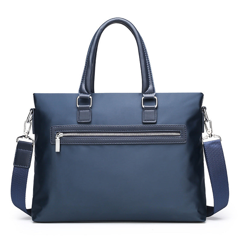 Blue A4 file bag briefcase with top handles, front zip pocket, and crossbody shoulder straps
