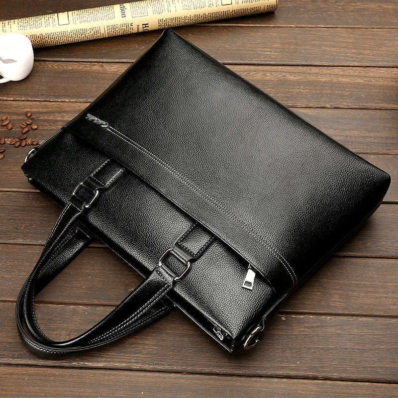 Men's leather one-shoulder computer bag in black with buckle straps and front flap pocket.