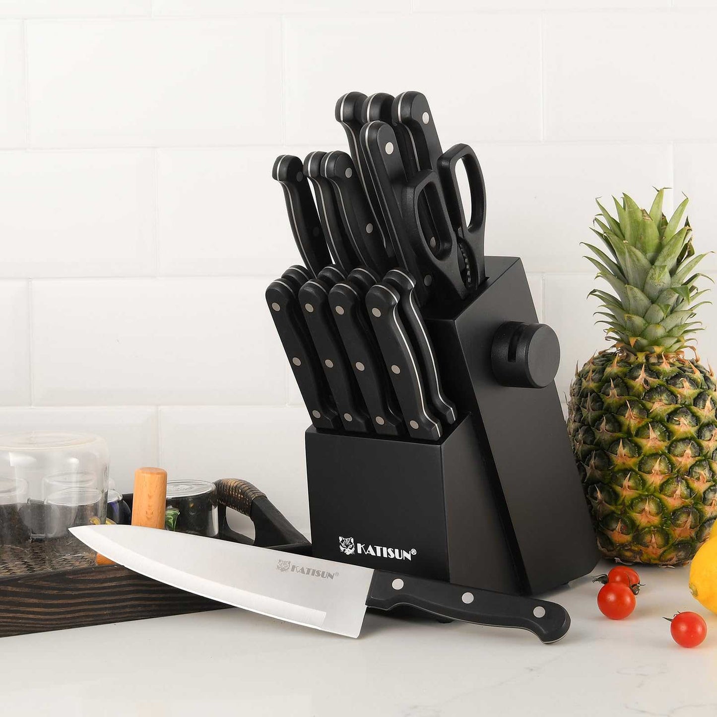 Black kitchen knife set on countertop with multiple knives in storage block