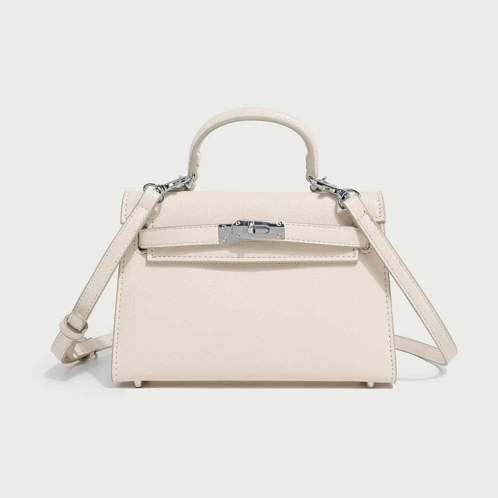 Cream structured tote bag with top handle, silver-tone hardware, front clasp