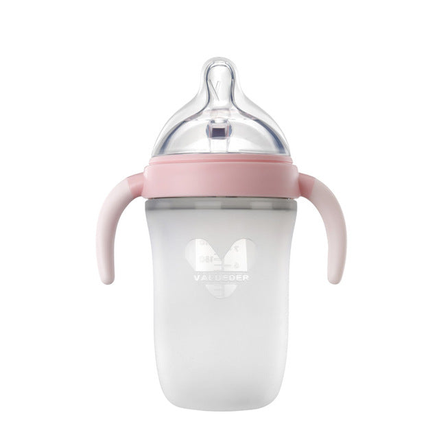 Baby feeding bottle with pink spout lid, clear nipple, and side handles on white body