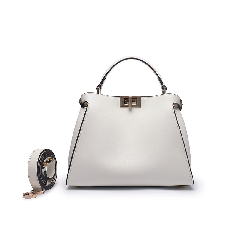 White crossbody handbag with metal clasp, top handles, and crossbody strap