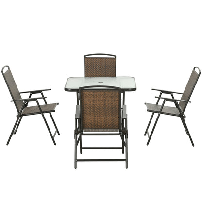 Brown wicker patio dining set with glass table and four folding chairs, umbrella hole