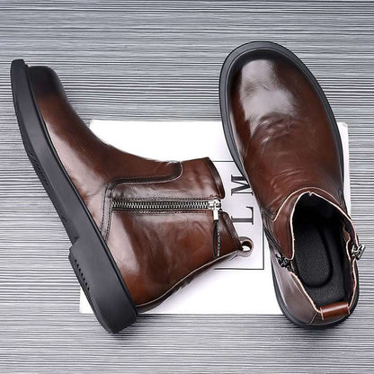 Brown leather ankle boots with zippers on a textured surface