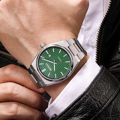 Men's steel strap wristwatch with green dial and silver hands on a wrist