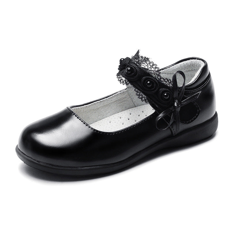 Black leather flats with rosette bow at ankle and perforated insole, low sole