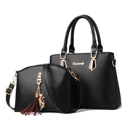 Black tote-style crossbody handbag with front oval pocket and tassel charm