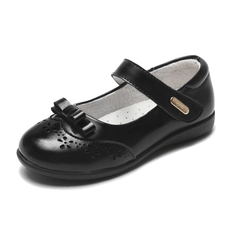 Black leather Mary Jane flats with T-strap, bow charm, and perforated toe