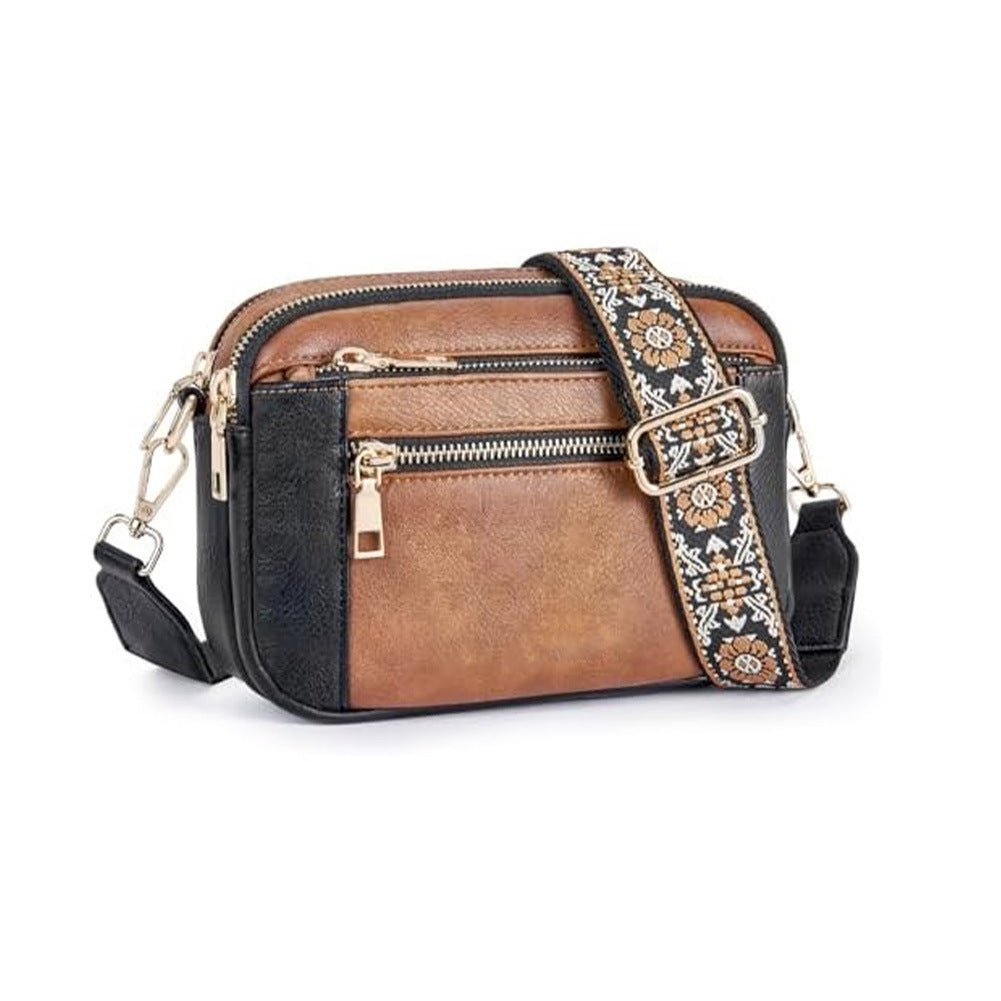 Brown crossbody bag with triple zippers and floral patterned crossbody strap.