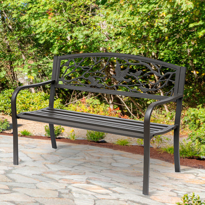 Brown cast iron garden bench with arched bird-and-branch backrest and slat seat