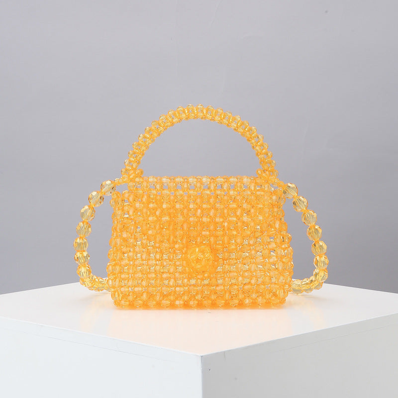 Yellow beaded mini tote bag with arched top handle and woven mesh bead body