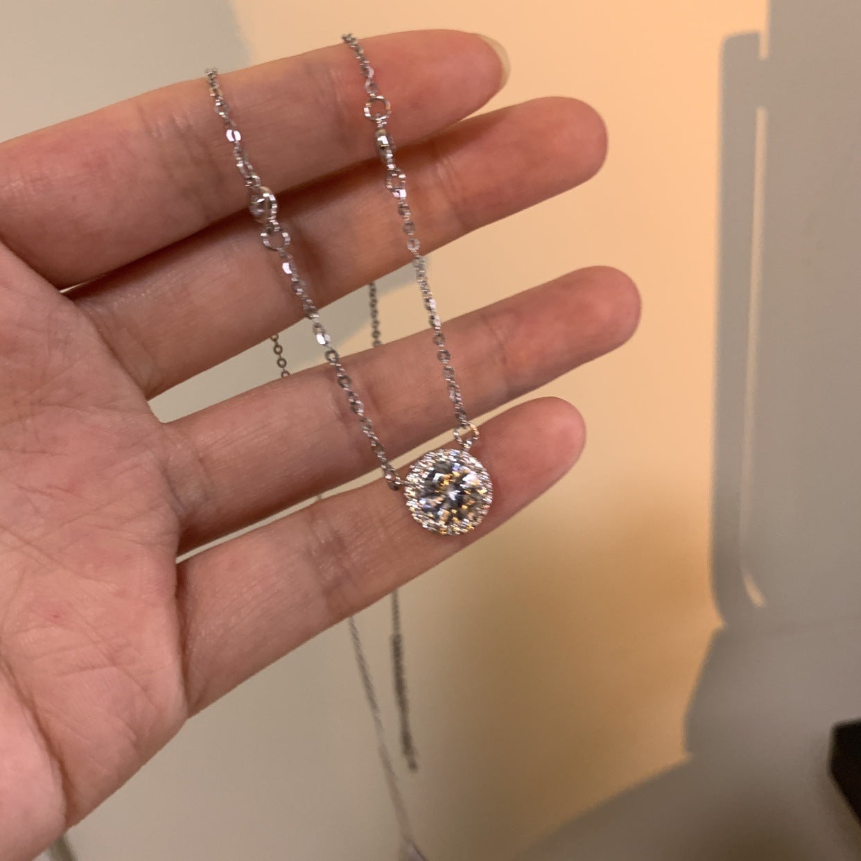 Silver charm necklace with round crystal pendant on thin dangling chain