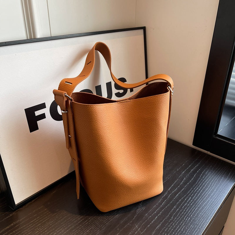 Pebble-grain bucket bag in caramel brown with drawstring top and shoulder strap