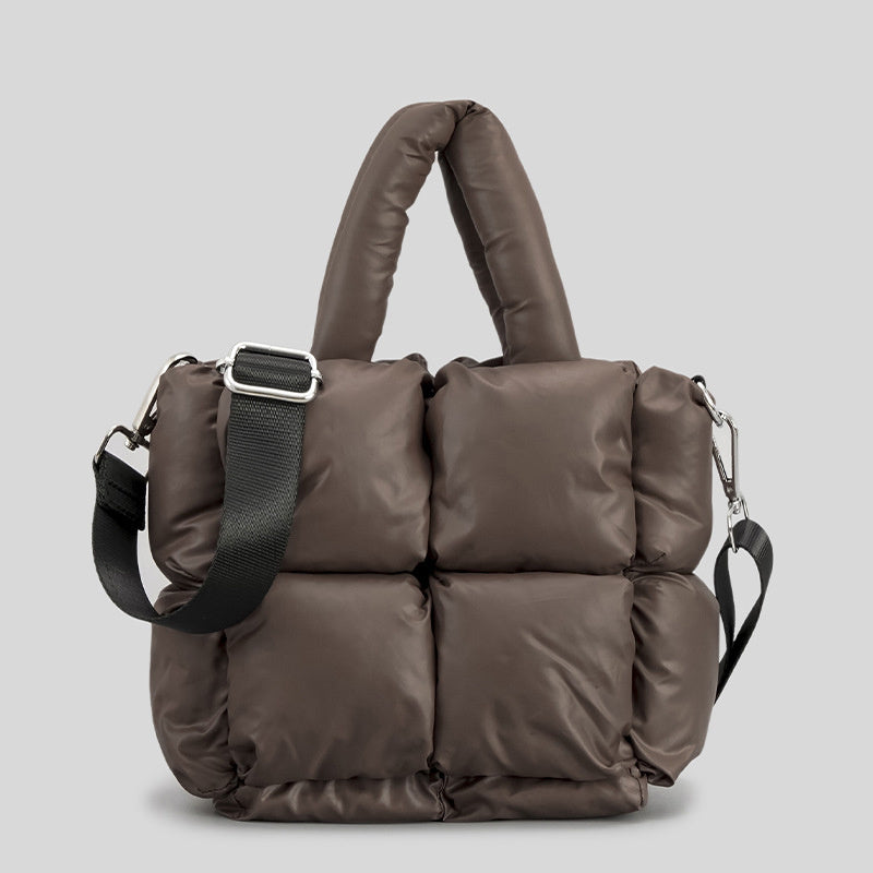 Puffer one-shoulder handbag in brown with quilted blocks, top handles, and crossbody strap