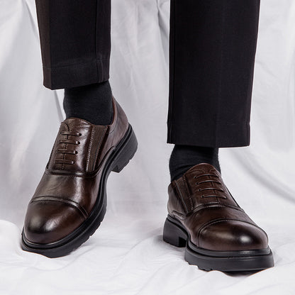Brown dress shoes worn with black pants and socks on a white background
