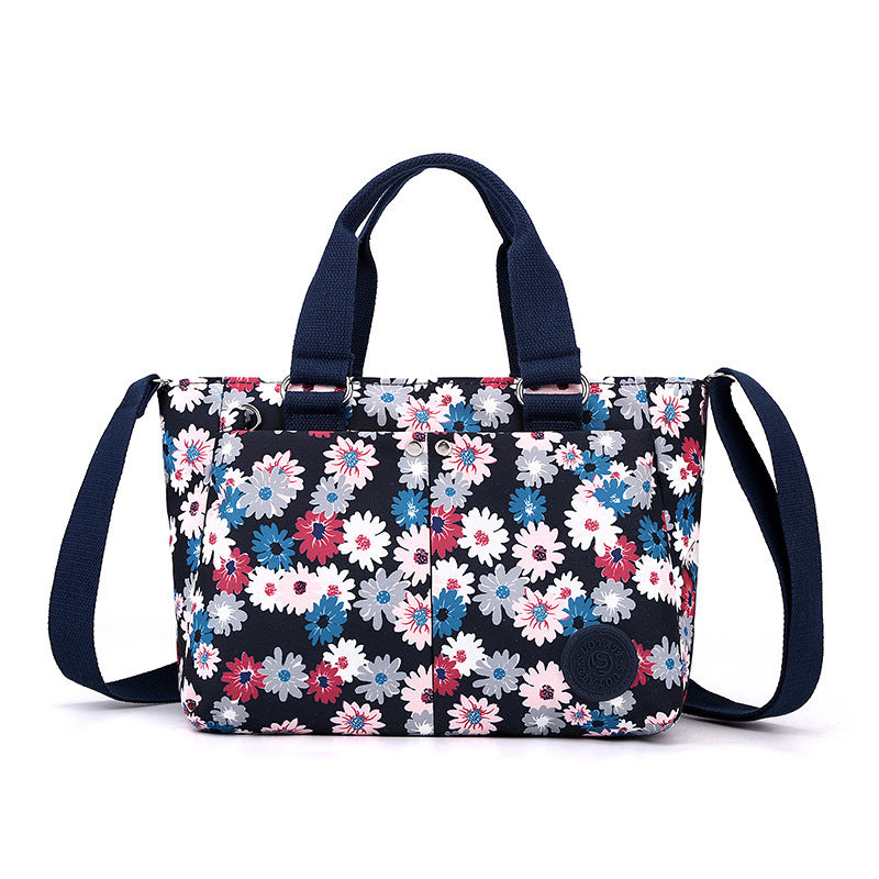 Waterproof shoulder bag with navy floral print and matching navy webbing shoulder straps
