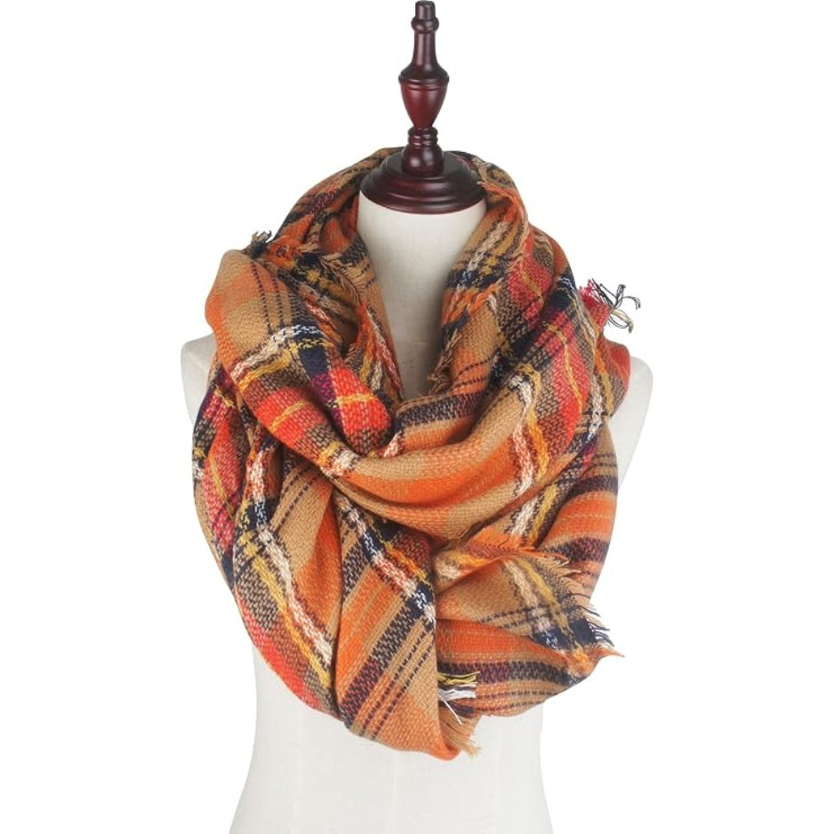 Oversized plaid scarf wrap in orange, red, and navy with fringe trim on corners