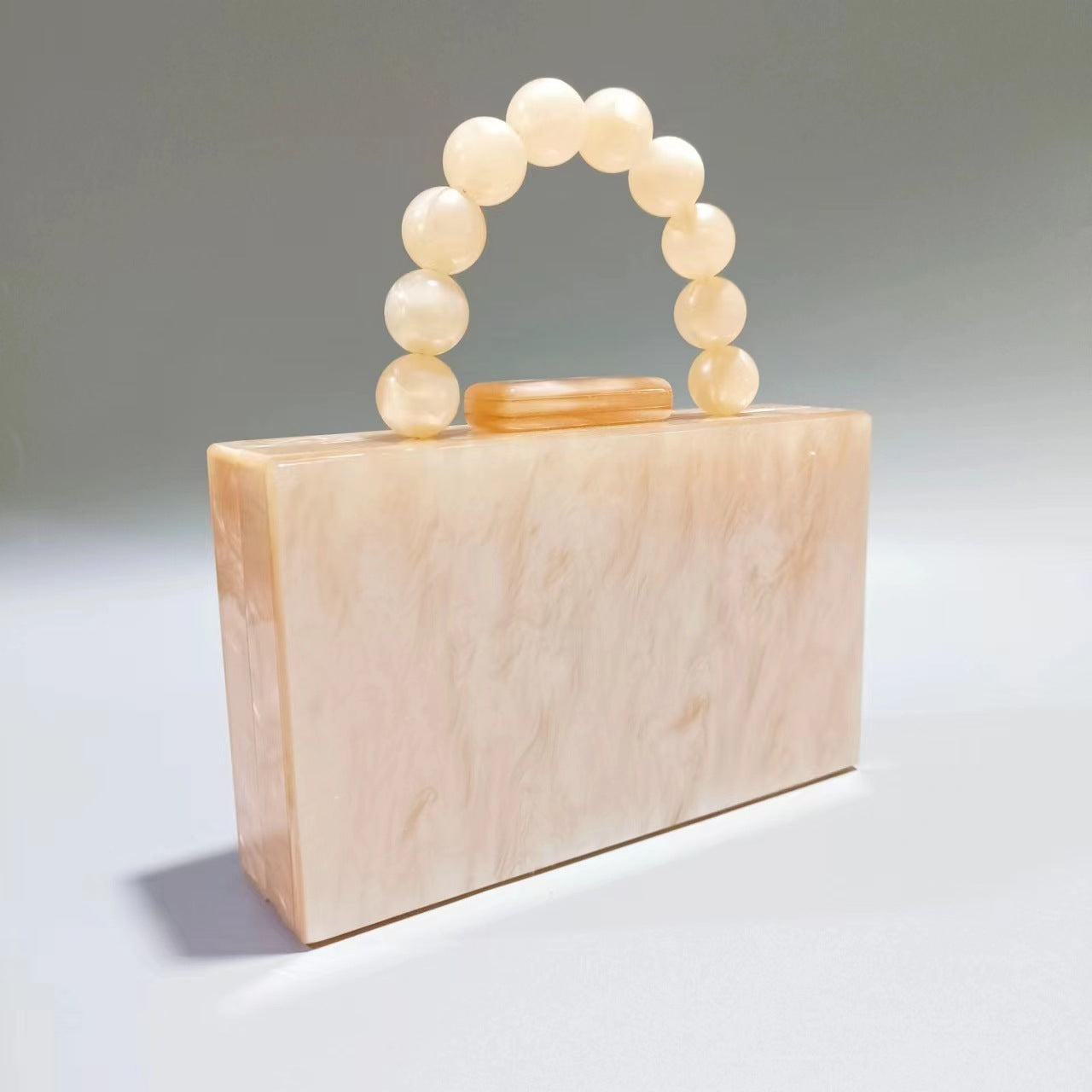 Women's acrylic evening bag with pale cream body and cream round beaded handle