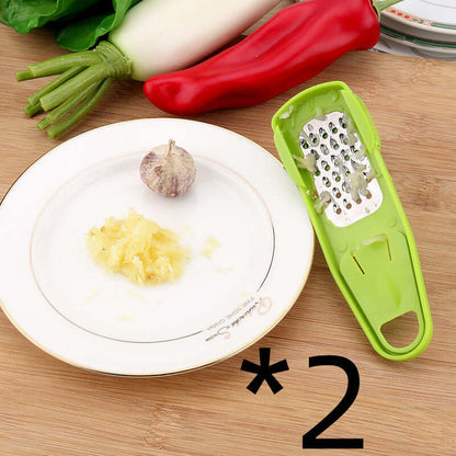 Light green manual garlic masher with grater holes and wide handle