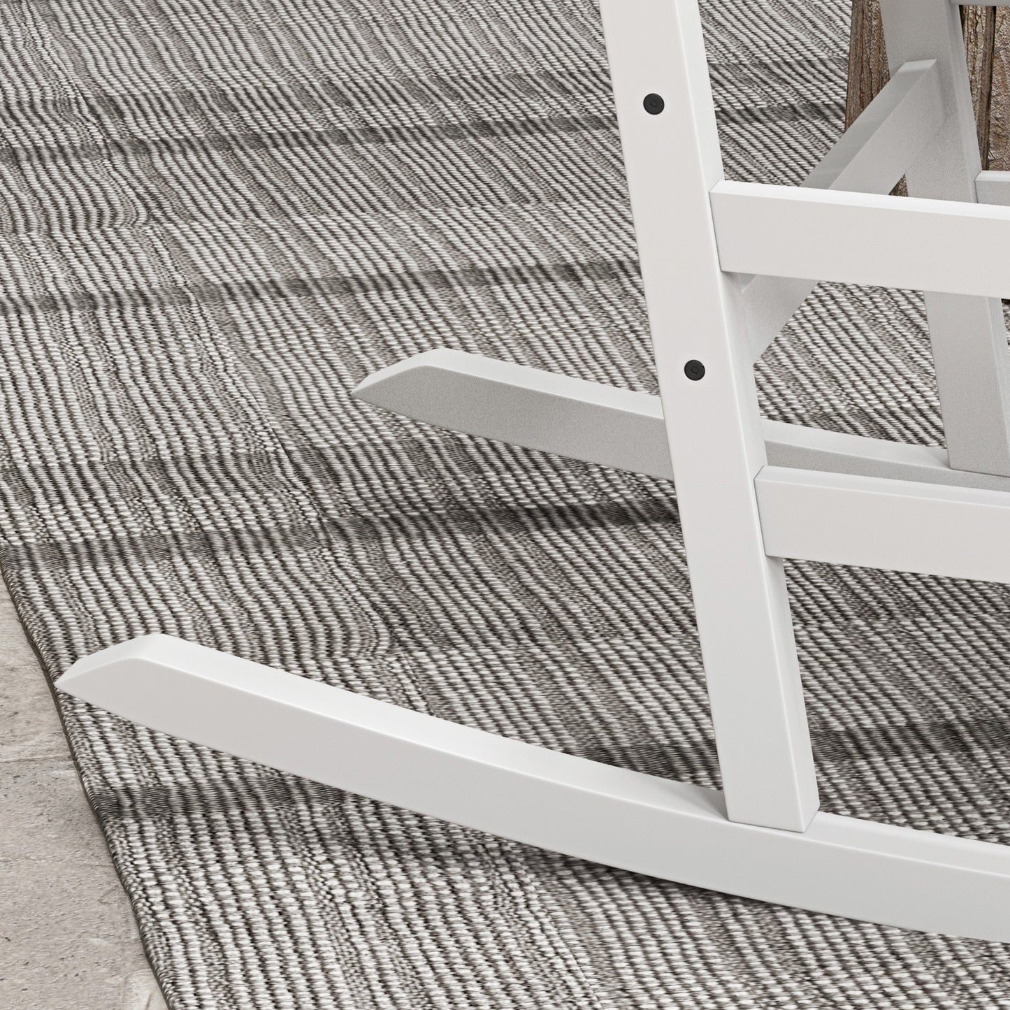 White wooden rocking chair base and side rail close-up over textured rug