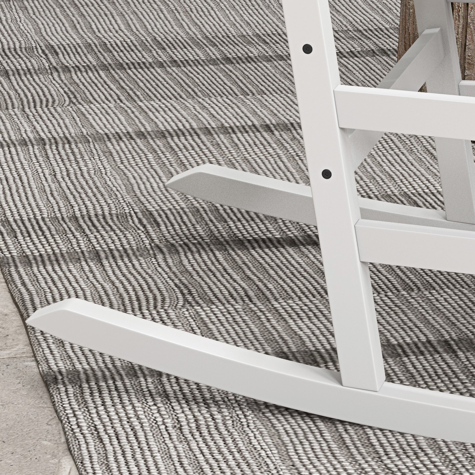 White wooden rocking chair base and side rail close-up over textured rug