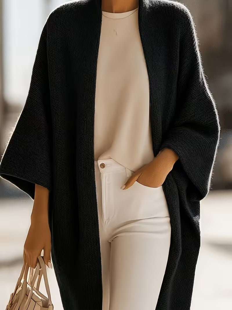 Black knit shawl jacket with draped open front, open neckline, and short batwing sleeves