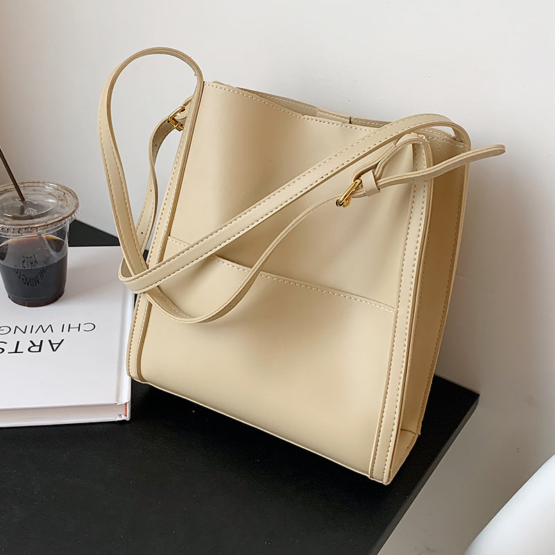 Cream leather retro shoulder bag with long strap, gold-tone hardware, angled front panel design