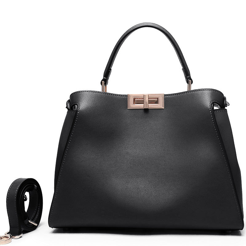 Black crossbody handbag with top handles, rose-gold lock clasp and textured finish