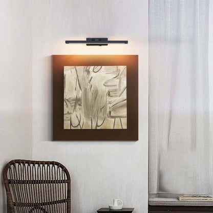 Black rechargeable LED picture light mounted above framed wall art
