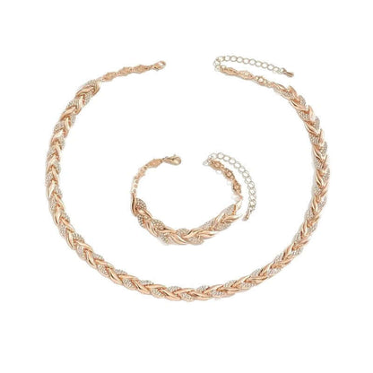 Rhinestone leaf jewelry set in rose gold tone: necklace and bracelet laid flat.