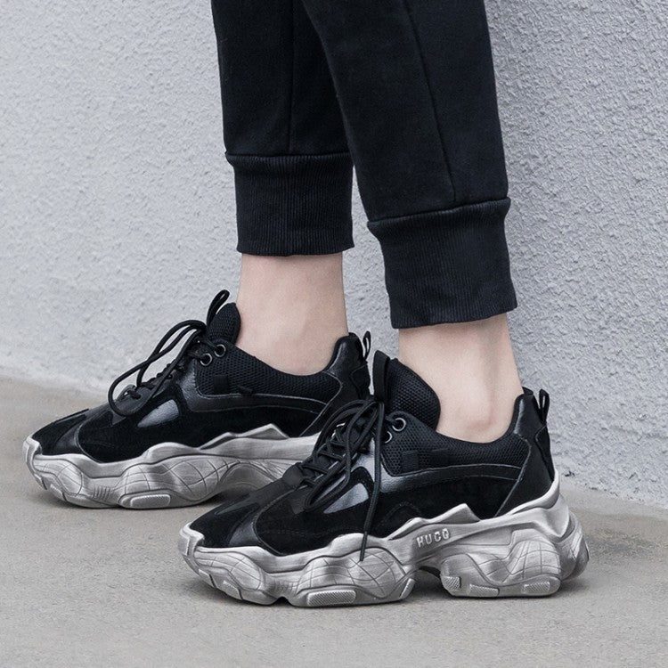 Black platform sneakers on feet with chunky silver tread sole