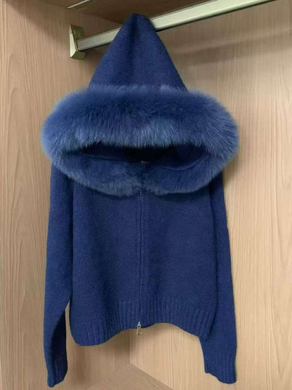 Blue sweater with fur collar hanging on a wooden door