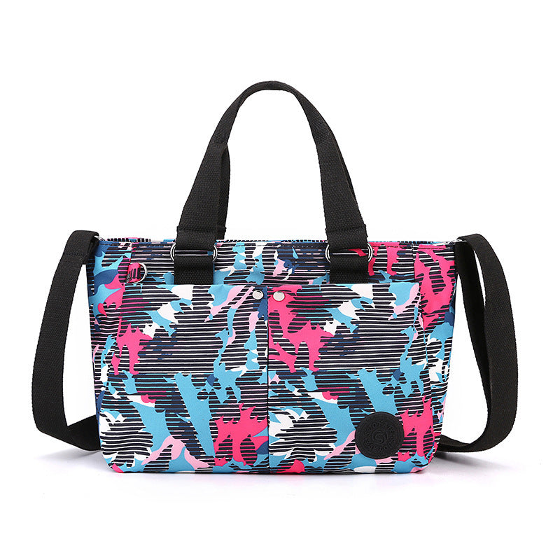 Waterproof shoulder bag with blue-and-pink camouflage print and black webbing straps