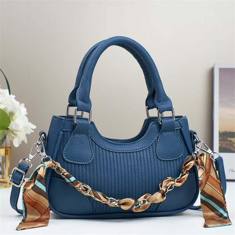Blue braided chain crossbody handbag with top handles, front patch pockets.