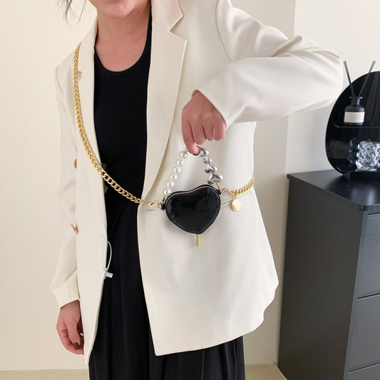 Mini heart-shaped handbag with black metallic finish, faux pearls, and gold chain strap