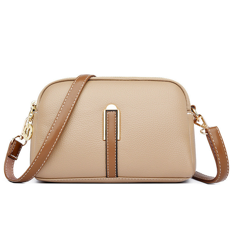 Light beige textured shoulder bag with zip top and tan front strap detail