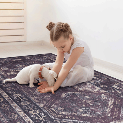Washable area rug with distressed geometric border and central motifs in dark black and burgundy
