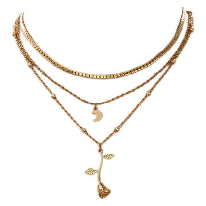Gold necklace with multiple layers and floral pendant on a white background