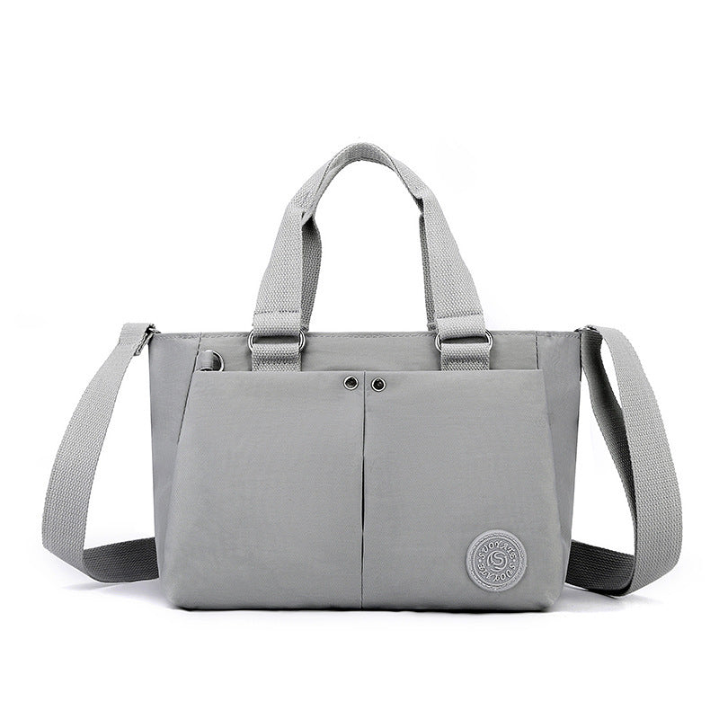 Waterproof shoulder bag in light gray with front seam and gray webbing shoulder strap
