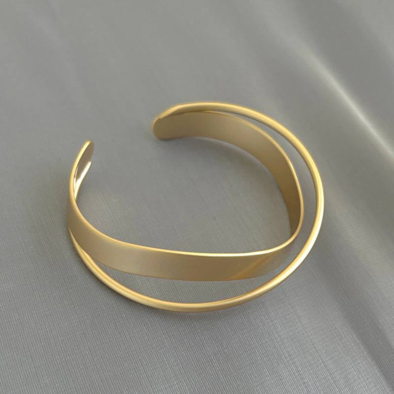 Gold open bangle cuff bracelet with smooth curved ends and wide arc