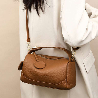 Tan/brown leather pillow bag with front flap and adjustable crossbody strap