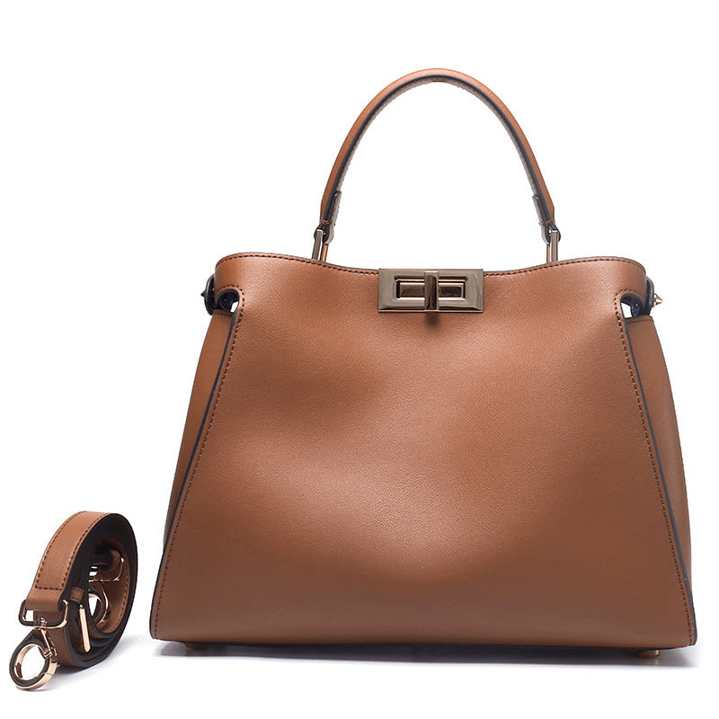 Caramel crossbody handbag with metal clasp, top handles, and side crossbody strap
