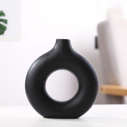 Dark ceramic vase with round center cutout, smooth matte finish