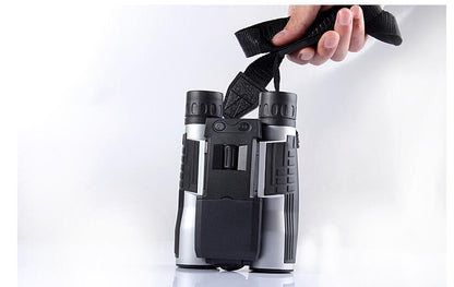 Binoculars held by a hand against a white background