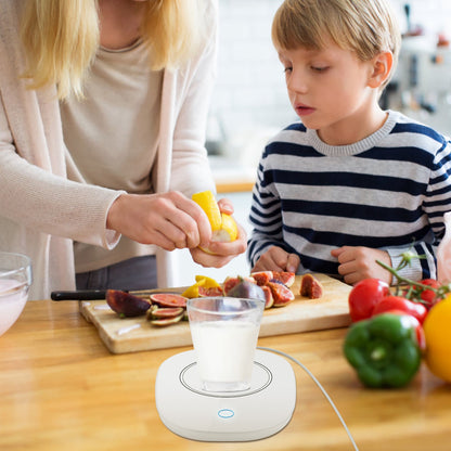 White mug warmer on table holding a cup while a person serves drinks