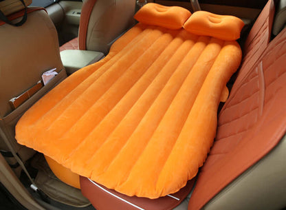 Orange ribbed inflatable car mattress with two raised pillows in car