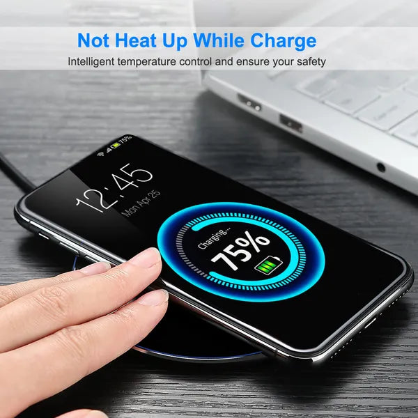 Black wireless charger pad with smartphone lying on it during charging
