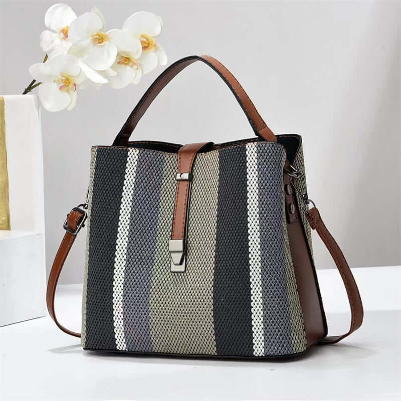 Large crossbody handbag in dark gray with white vertical stripes and brown top handles